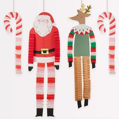 three paper christmas decorations hanging from strings