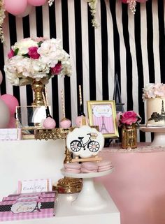 a table topped with lots of cake next to pink and white flowers in vases