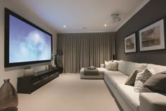 a living room filled with furniture and a flat screen tv mounted to the side of a wall