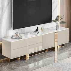 an entertainment center with a flat screen tv mounted on it's sideboard in a living room