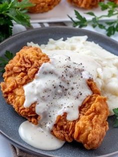 fried chicken with gravy and mashed potatoes on a plate