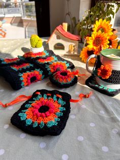 crocheted coasters and cups on a table with sunflowers