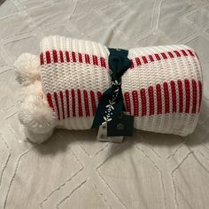 a stuffed animal wrapped in a blanket on top of a white bedspread with a green ribbon