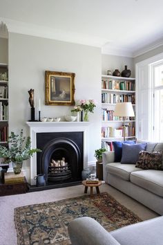 a living room filled with furniture and a fire place under a painting on the wall