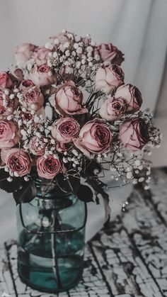 a vase filled with pink roses on top of a table