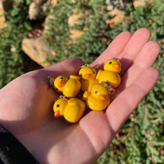 small yellow rubber ducks sitting in the palm of someone's hand