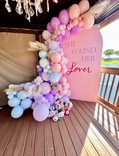 a pink and white balloon arch with the words she found her love on it