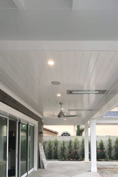 an empty patio with white walls and ceiling fans