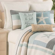 a bed with blue and white comforters, starfish pillows and palm trees in the background