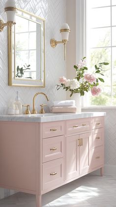 a bathroom with pink vanity and gold fixtures, flowers in vase on the sink counter