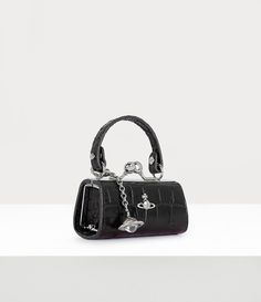 Our Doll bag features a an all-leather design, complete with this season's croc-embossed finish. The miniature silhouette draws inspiration from toy doll bags, featuring an intricately engraved kiss lock closure and our dangle orb motif, symbolising Vivienne Westwood's idea of taking tradition into the future. Vivienne Westwood Mini Bag, Vivienne Westwood Black Bag, Vivienne Westwood Bag, Vivienne Westwood Accessories, Black Vivienne Westwood, Vivienne Westwood Clutch, Vivienne Westwood Bags, Doll Bag, Womens Designer Bags