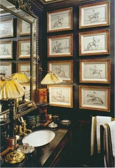 a bathroom with pictures on the wall and a sink in front of a large mirror