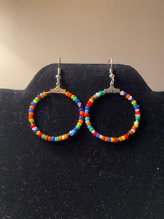 Bohemian styled hoop earrings.  Made with multicolored seed beads.  Multicolored to go with any outfit! * All materials were cleaned and sanitized prior to use and kept in a clean smoke-free environment. Comes packaged in a mesh drawstring bag. Crafts 2025, Seed Bead Hoop Earrings, Upcycled Earrings, Bead Hoop Earrings, Earrings Beaded, Button Crafts, Beaded Hoop Earrings, Beaded Hoops, Seed Bead Earrings