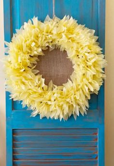 a blue door with a yellow wreath hanging on it