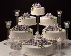 a table topped with lots of white and purple cakes