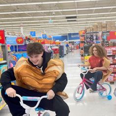 a man riding a bike in a store next to a woman on the other side