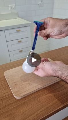 a man is using a toothbrush to brush his teeth on a cutting board in the kitchen