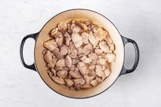 a pot filled with food sitting on top of a counter next to a white table