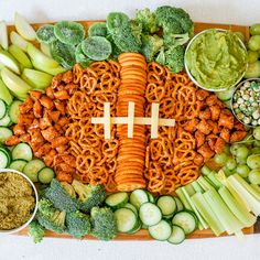 a football shaped platter filled with vegetables and dips