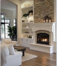 a living room filled with furniture and a fire place in the middle of it's fireplace