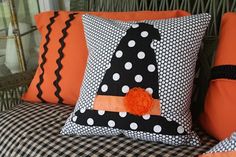 a black and white couch with orange pillows on it's back, decorated with polka dots