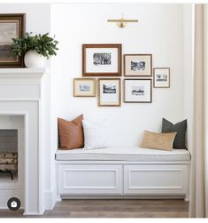 a living room filled with furniture and framed pictures on the wall above a fire place