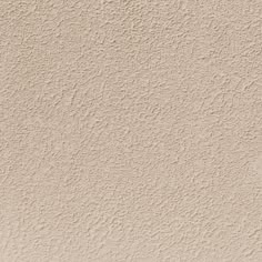 a beige stucco wall textured with white paint