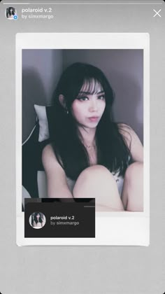 a woman with long black hair sitting on top of a bed next to a white wall