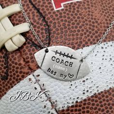 a close up of a football with a tag on it that says coach name has my heart