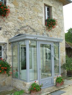 an old stone building with flowers on the windows