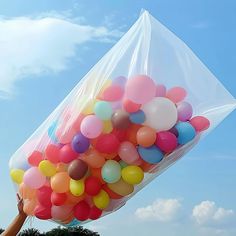 a person holding a bunch of balloons in the air