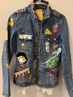 a denim jacket with patches and tassels on it