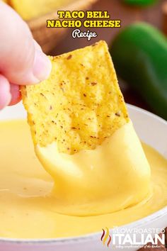 a hand dipping cheese into a bowl of taco bell nacho cheese