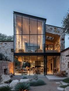 a modern house with large windows and stone walls