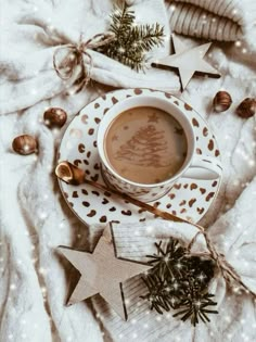 a cup of hot chocolate on a saucer surrounded by christmas decorations and star ornaments