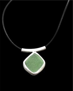 "Handmade sea glass leather cord pendant with a beautifully bright light jade green sea glass nugget. The glass is sourced in Kintyre on the west coast of Scotland.  The naturally tumbled sea glass is set within a fine silver bezel setting, open-backed to allow the light to shine through and enhance the subtle colour of the glass. The pendant is suspended on a sterling silver tube bail on an 16\" black leather lace with sterling silver fittings.  Makes an ideal gift for ladies or girls, wife or Minimalist Green Glass Jewelry, Green Sea Glass Necklaces For Jewelry Making, Green Sea Glass Necklace For Jewelry Making, Green Pendant Jewelry With Adjustable Cord, Adjustable Green Recycled Glass Necklace, Green Recycled Glass Pendant Jewelry, Green Adjustable Cord Jewelry Gift, Minimalist Green Jewelry With Recycled Glass, Seaglass Necklace