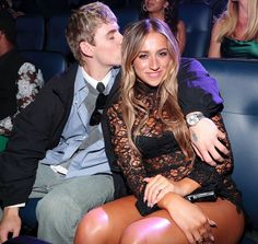 a man and woman sitting next to each other in front of a crowd at a concert