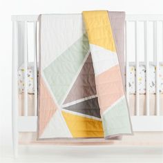 a baby crib with a blanket on top of it