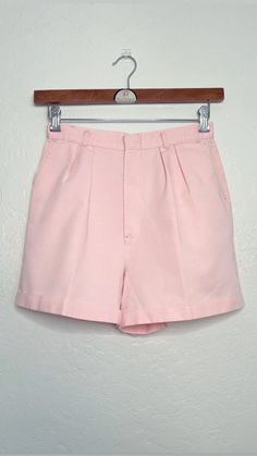 **90s Vintage Pastel Pink High-Waisted Pleated Shorts**  These 90s vintage high-waisted shorts in a soft pastel pink are the perfect blend of retro charm and effortless timeless style. Featuring a flattering pleated front, they offer a tailored but, relaxed fit that sits comfortably at the waist. Complete with functional side pockets, these shorts are both practical and stylish. The lightweight fabric and soft hue make them ideal for warm days, adding a sweet, feminine touch to any outfit. Wheth Vintage High Waist Bottoms For Spring, Fitted Pastel Bottoms For Spring, Vintage Short Bottoms For Spring, Vintage High Waist Summer Bottoms, Vintage High Waist Bottoms For Summer, Vintage Shorts For Spring, High Waist Vintage Bottoms For Summer, Retro Bermuda Shorts For Spring, Vintage Spring Short Bottoms