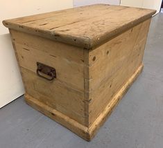 an old wooden box sitting on the floor in front of a white wall and door