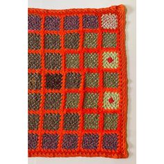 an orange crocheted square with squares on it