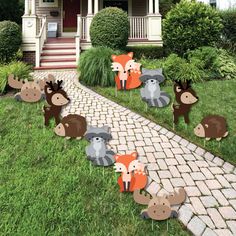 outdoor lawn decorations with woodland animals on the grass and brick path in front of a house