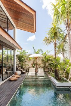 an outdoor swimming pool surrounded by palm trees