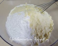 a bowl filled with flour and whisk on top of a table