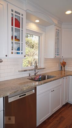 a kitchen with white cabinets and marble counter tops is seen in this image from the inside