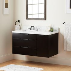 a bathroom with a sink, mirror and towel rack on the wall next to it