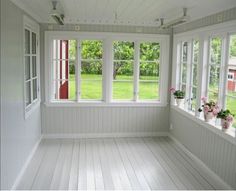 an empty room with white walls and windows