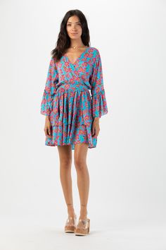 Elevate your wardrobe with our Felix MIni Dress. This charming long sleeve mini dress embraces the whimsical beauty of feminine style. With its flattering silhouette and playful ruffle detailing, this dress is guaranteed to make you feel effortlessly elegant and confident with every wear. Details: 100% Rayon Hand wash in cold water and Lay flat to dry Features: Unlined, V-neck overlap bodice, Tiered flowing sleeves with ruffle detail, Elastic waistband for adjustable fit, Self tie adjustable wai Blue Mini Long Sleeve Dress For Spring, Blue Mini Length Long Sleeve Dress For Spring, Summer Long Sleeve Dress With Ruffle Hem, Long Sleeve Dress With Ruffle Hem For Brunch, Long Sleeve Mini Dress With Ruffle Hem For Beach, Blue Long Sleeve Mini Dress With Ruffles, Turquoise Flowy Dress For Spring, Turquoise Flowy Long Sleeve Dress, Long Sleeve Ruffled Mini Dress For Beach