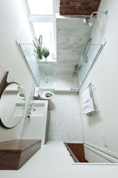 a small bathroom with a toilet, sink and shower stall in the middle of it