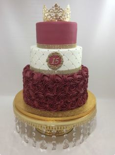 a three tiered cake decorated with roses and a gold crown on top is shown